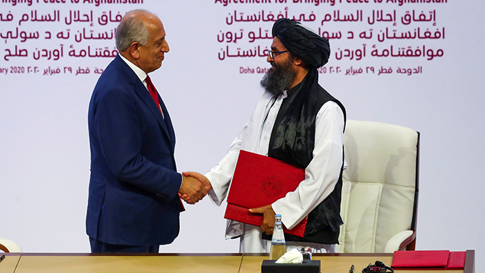 زلمی خلیلزاد، نماینده ویژه امریکا برای صلح افغانستان و ملا برادر، رییس دفتر سیاسی گروه طالبان در قطر توافق‌نامه‌ی صلح را امضا کرده‌اند. عکس: Reuters