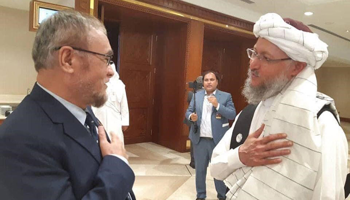 احوالپرسی محمد ناطقی، عضو هیأت دولت افغانستان و ملا عبدالسلام حنفی، عضو هیأت گروه طالبان در حاشیهی نشست مذاکرات صلح افغانستان/ عکس: شبکههای اجتماعی