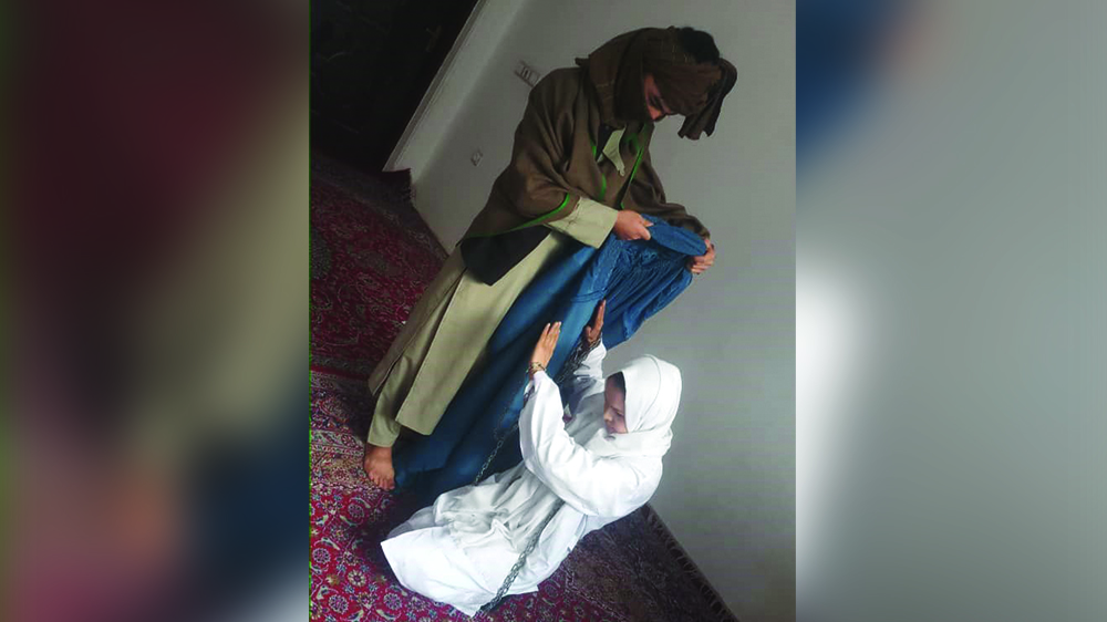 نمایش نمادین زنان معترض در غرب کابل. مردی به اجبار بر زن کفن‌پوش برقع می‌پوشاند.
